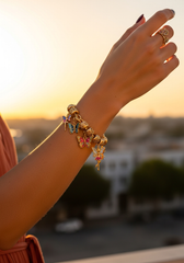 Brazo femenino con pulsera dijes mariposas al atardecer golden hour | Gheller