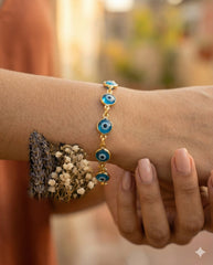 Detalle macro pulsera ojo turco dorada con cuentas azules y flores secas | Gheller