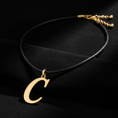 Dije de inicial C en oro laminado — fotografía artística de lujo