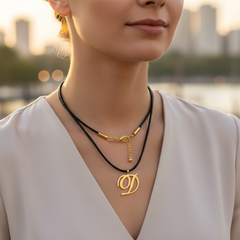 Modelo usando collar de inicial D en oro laminado con cordón de cuero negro