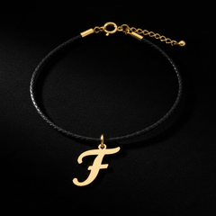 Dije de inicial F en oro laminado — fotografía artística de lujo