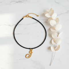 Dije inicial I en oro laminado 18k — composición flatlay con accesorios