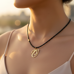Modelo usando collar de inicial O en oro laminado con cordón de cuero negro