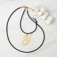 Dije inicial Y en oro laminado 18k — composición flatlay con accesorios