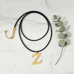 Dije inicial Z en oro laminado 18k — composición flatlay con accesorios