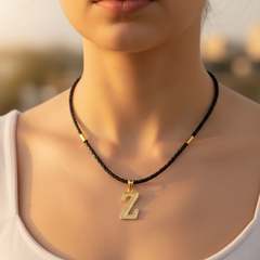 Modelo usando collar de inicial Z en oro laminado con cordón de cuero negro